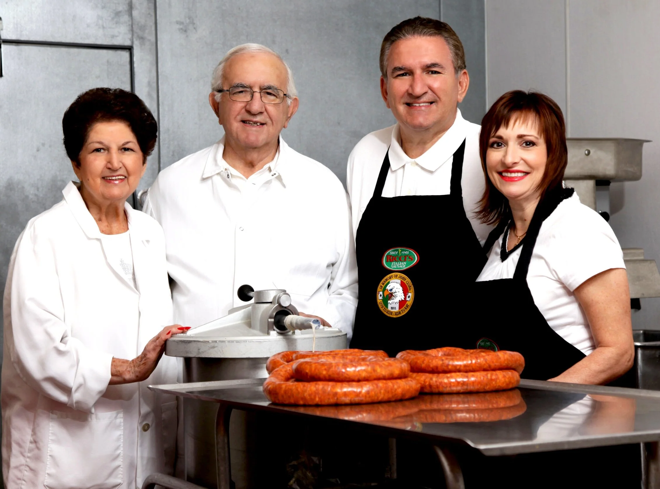 Four members of the Ricci family in their McKees Rocks shop, with fresh coils of sausage on the table in front of them